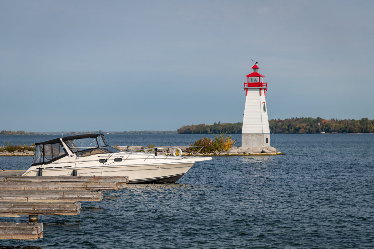 Lighthouse on a lake and a moored boat in the foreground
