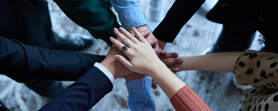 people putting their hands in the middle