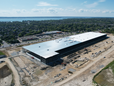 large industrial building development with lake in background