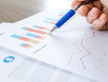pen on paper with graphs and charts